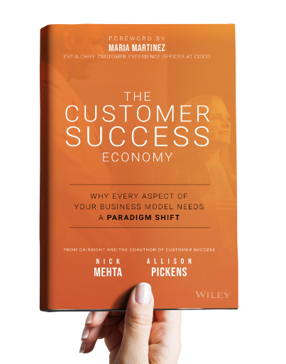 A hand holding the Customer Success Economy book